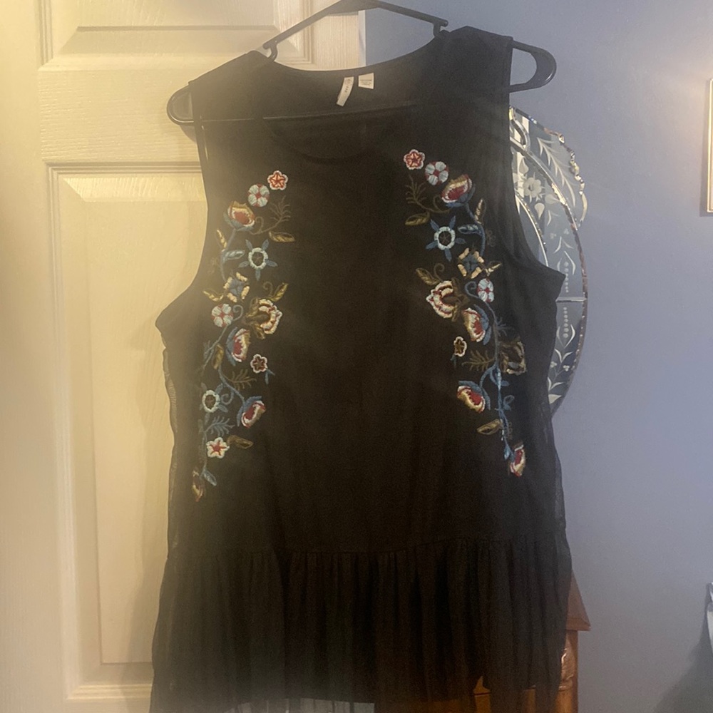 Sleeveless embroidered ladies with sheer material with attached cami.